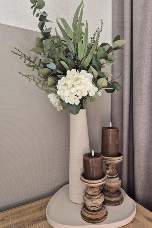 Stijlvolle vaas met wit boeket en sfeervolle accessoires