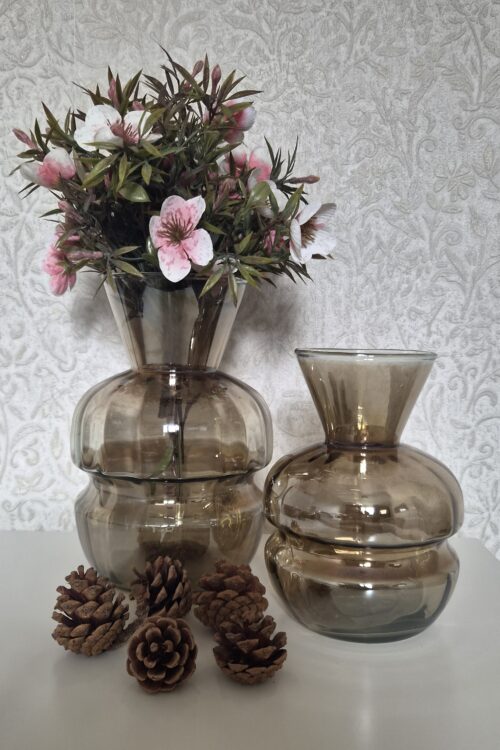 Sfeervolle set van twee amberkleurige vazen met boeket en decoratieve dennenappeltjes.
