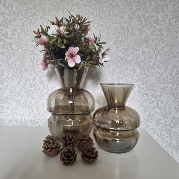 Sfeervolle set van twee amberkleurige vazen met boeket en decoratieve dennenappeltjes.